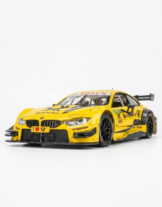 Studio shot of 1:24 yellow BMW M4 DTM Deutsche Post livery diecast metal model on a white background.