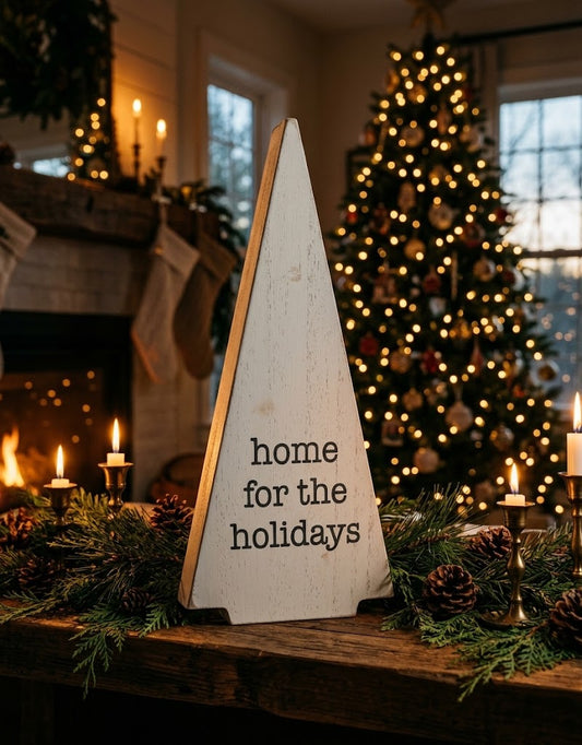 Rustic white wooden Christmas tree sign styled on a warm fireplace mantel with pine garland and glowing candles, Christmas home accents in Lebanon.