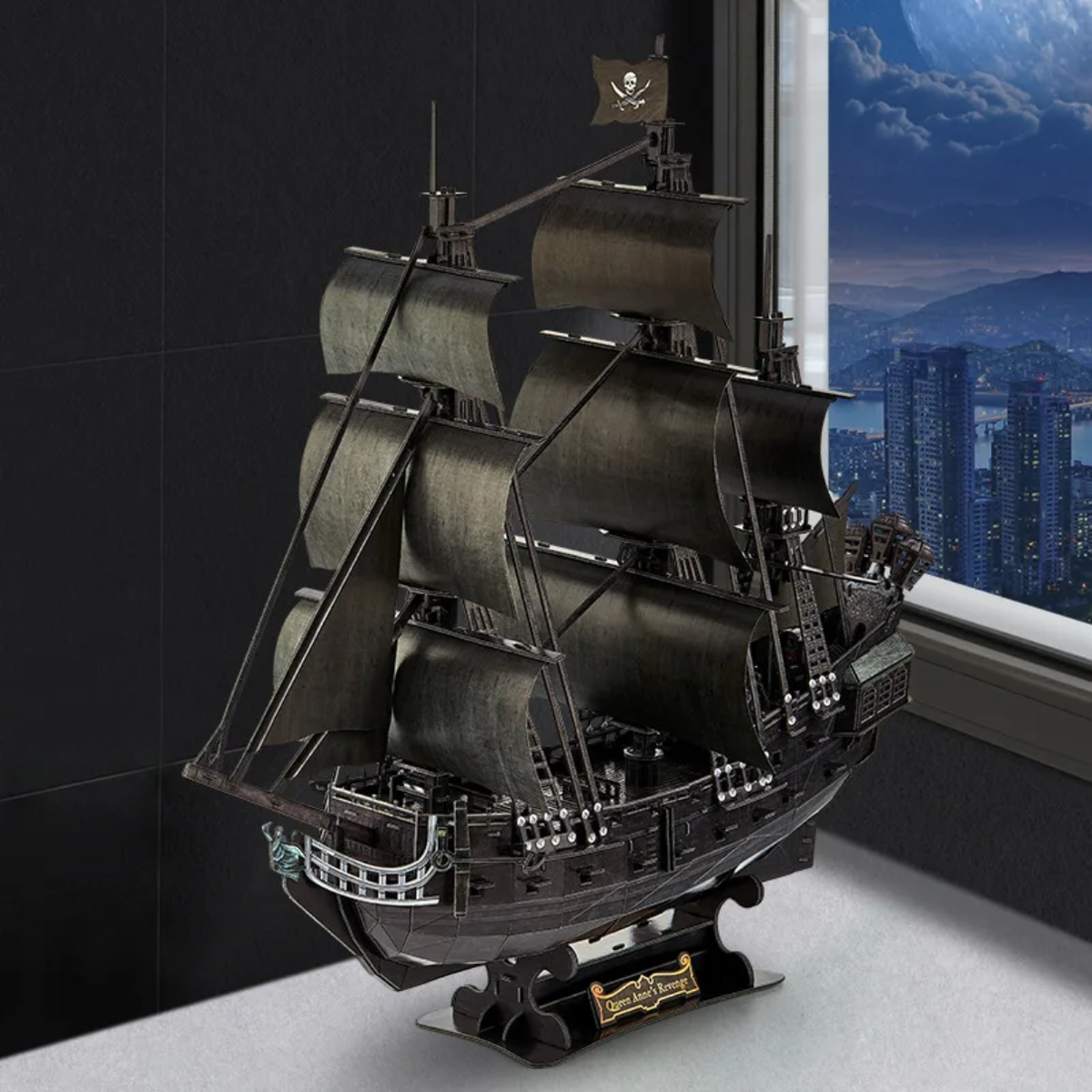 Assembled Queen Anne's Revenge pirate ship model displayed on an office desk with city night view, in stock at Gadgets Lebanon.