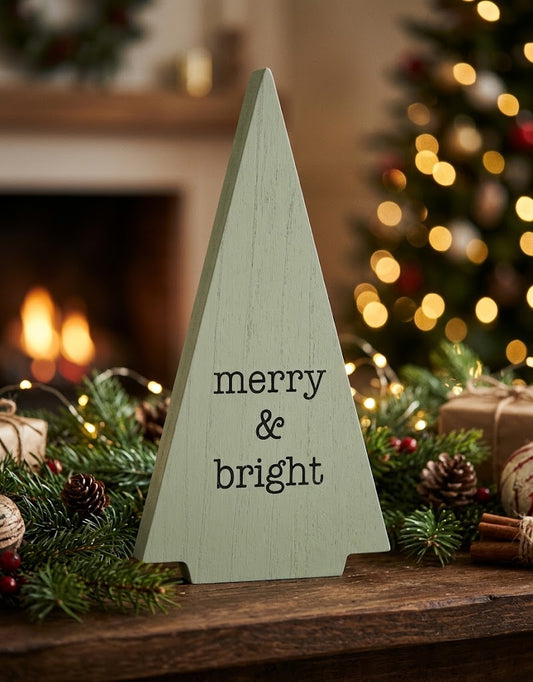 Sage green wooden Christmas tree decoration styled on a festive fireplace mantel with pine garland and warm holiday lights in Beirut, Lebanon.