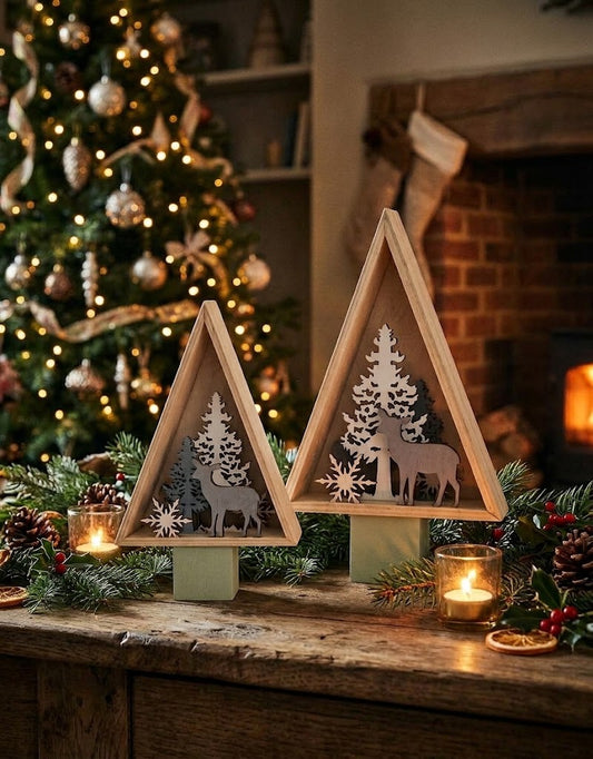 Rustic wooden Christmas tree figurines on a holiday dining table surrounded by pine garlands, candles, and a glowing tree in Lebanon.