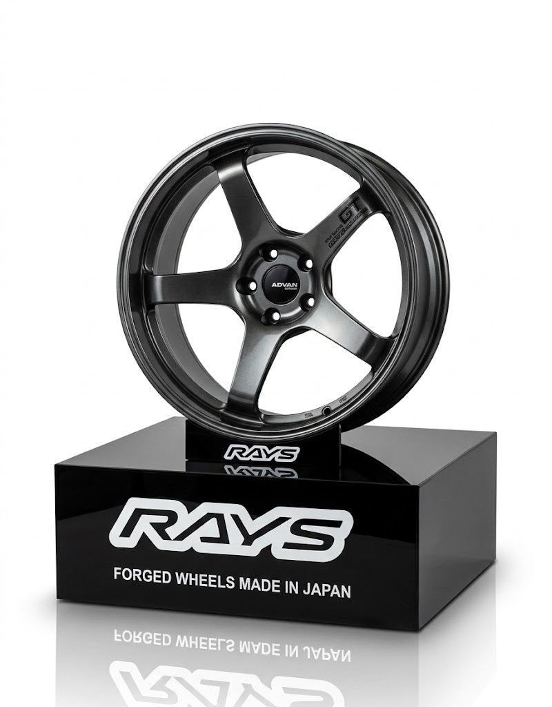 10cm gunmetal alloy wheel replica mounted on a gloss black Rays branded tabletop display stand.