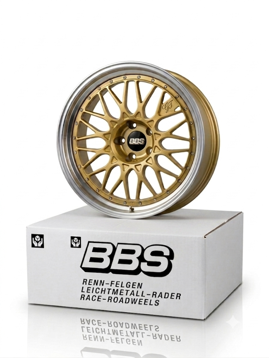 Gold BBS GT style miniature aluminum rim resting on vintage white motorsport packaging box