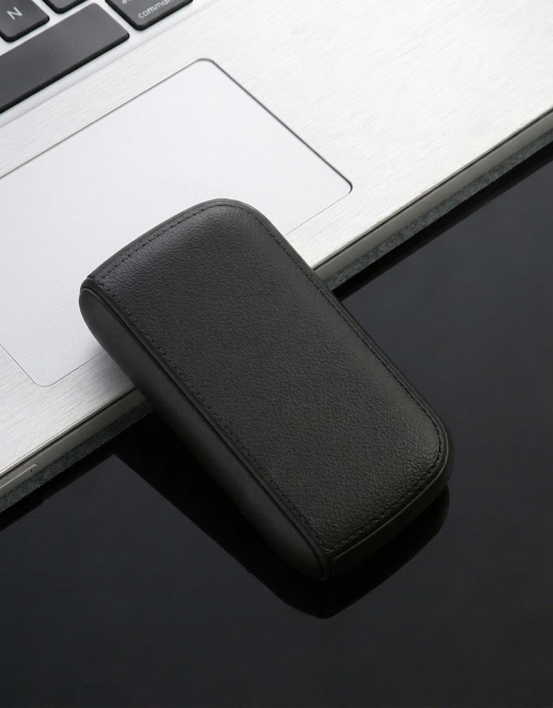 Premium black leather texture cigarette case with built-in USB flameless lighter on a modern laptop desk setup