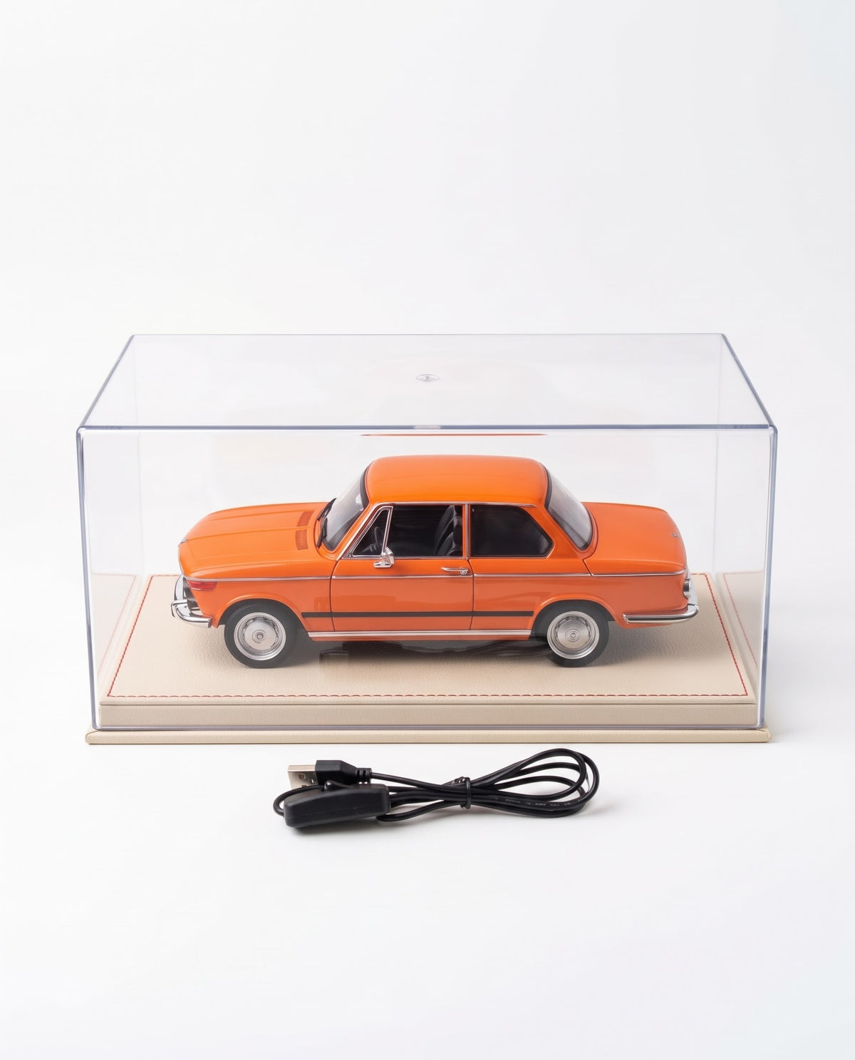1:18 scale orange BMW 2002 tii diecast alloy collector car shown inside a clear acrylic showcase box with leatherette base and USB power cable; available at Gadgets Lebanon with nationwide cash on delivery