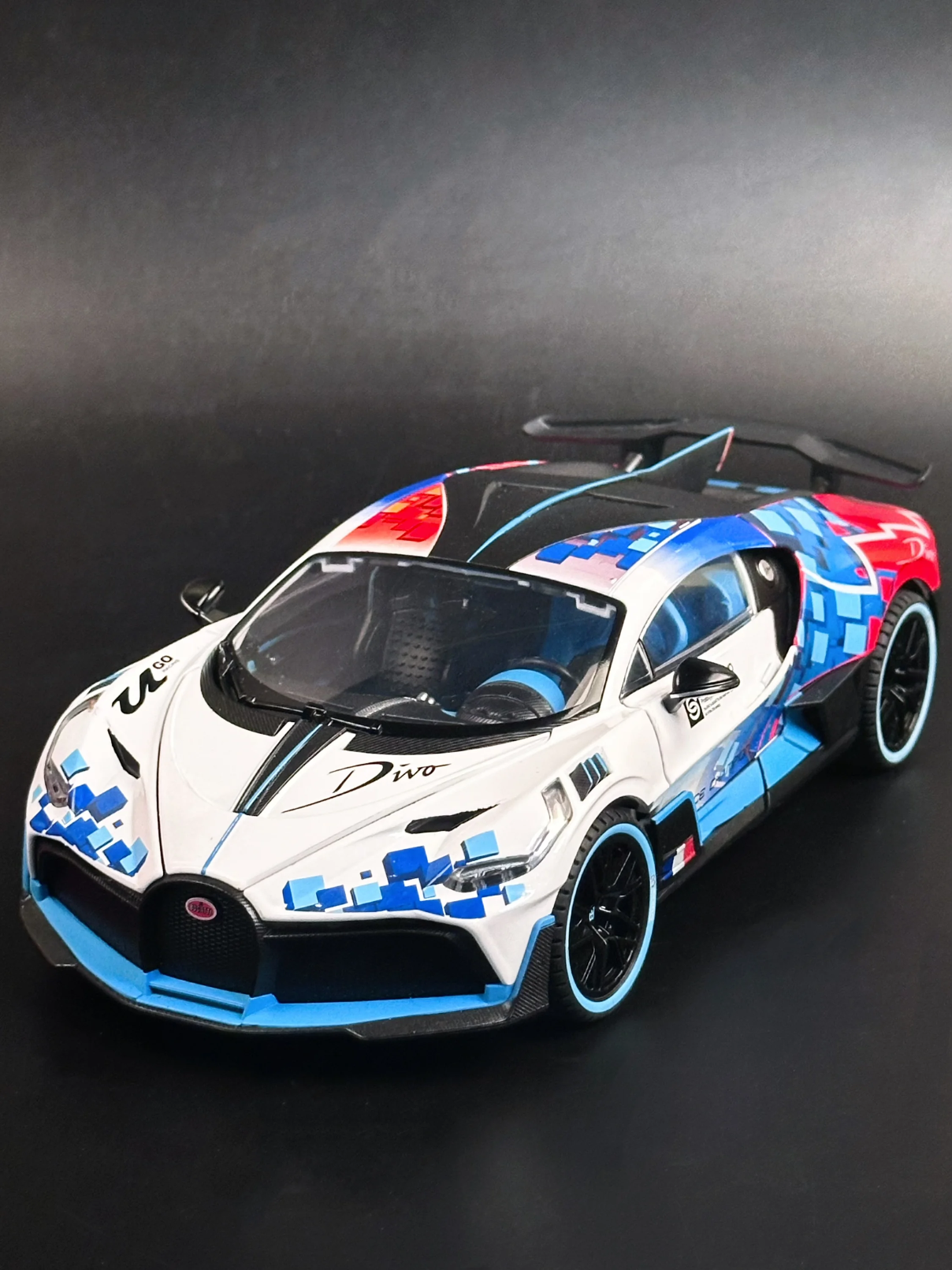1:18 scale Bugatti Divo alloy diecast model car in white and blue racing livery, front three-quarter view.