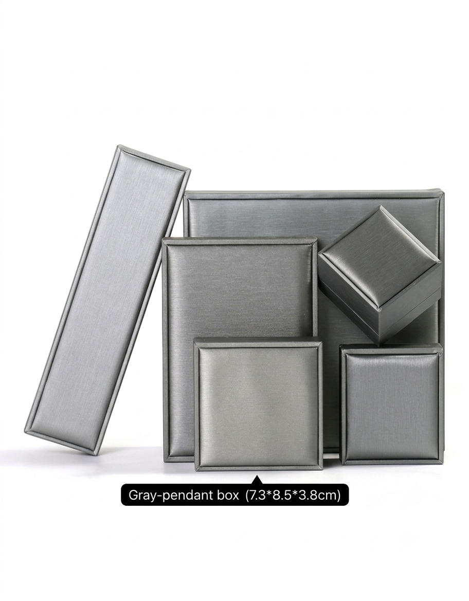 Elegant brushed metallic gray necklace gift box packaging with protective cushioned display inserts.