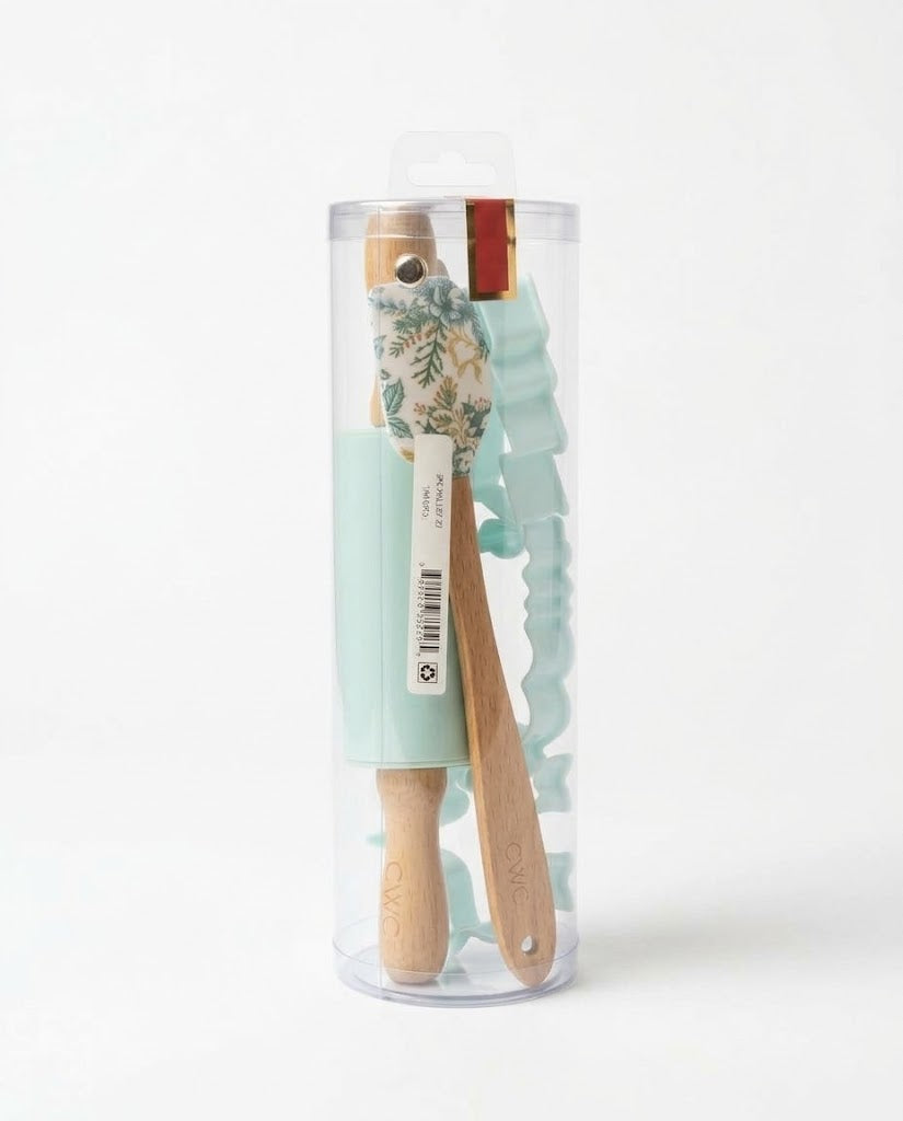 Mint green mini Christmas baking set in clear cylinder packaging with pinecone botanical spatula, mini wooden roller, and cookie cutters.