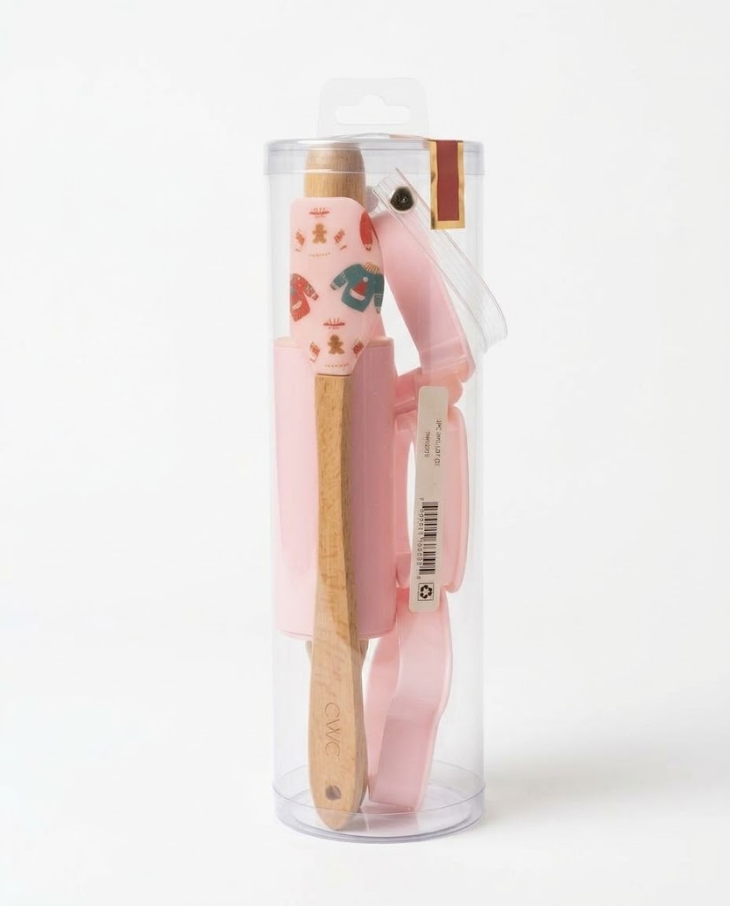 Pink Christmas mini baking set in clear tube featuring gingerbread sweater silicone spatula, mini wooden rolling pin, and cookie cutters.