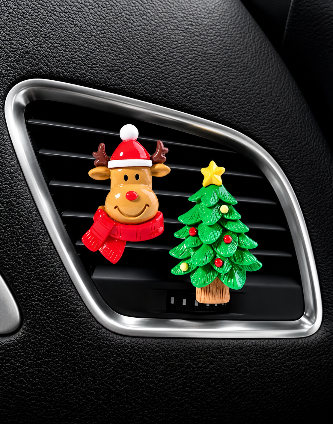 Pair of holiday car air freshener vent clips with a smiling reindeer and decorated Christmas tree attached to a modern car AC grille.