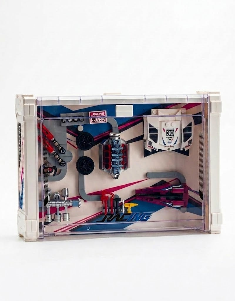 Assembled V8 engine, pistons, wheels, and aerodynamic body panels arranged inside an acrylic wall-mountable display case