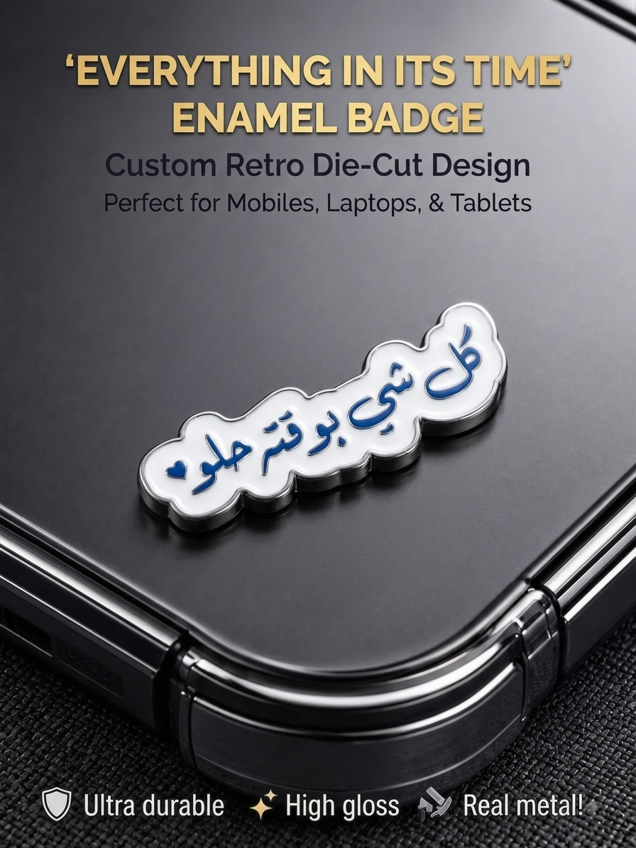 White and blue retro die-cut enamel sticker badge reading "Everything in its time" in Arabic calligraphy affixed to the back of a phone.