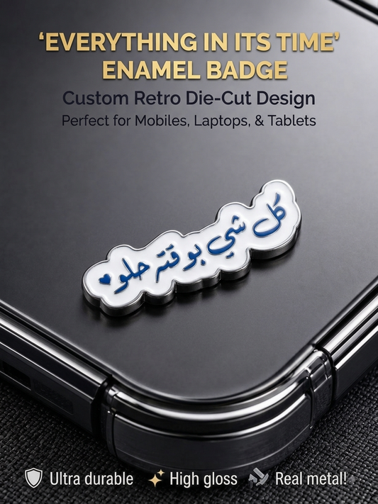White and blue retro die-cut enamel sticker badge reading "Everything in its time" in Arabic calligraphy affixed to the back of a phone.