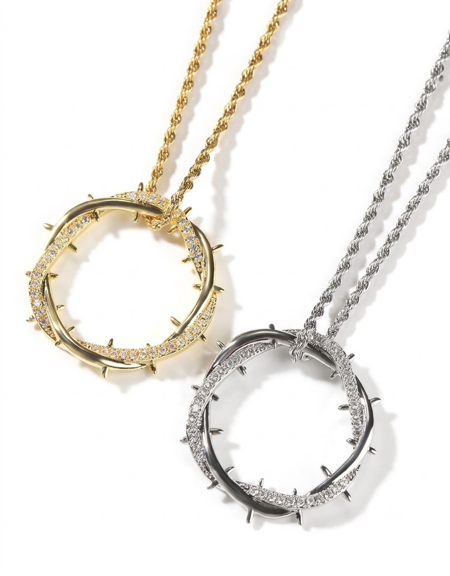 Side-by-side view of 18K gold and silver-plated crown of thorns iced pendant necklaces on matching rope chains.