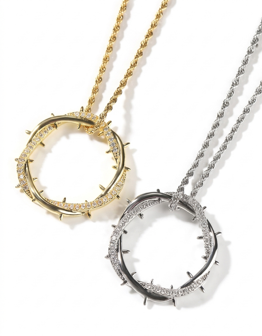 Side-by-side view of 18K gold and silver-plated crown of thorns iced pendant necklaces on matching rope chains.