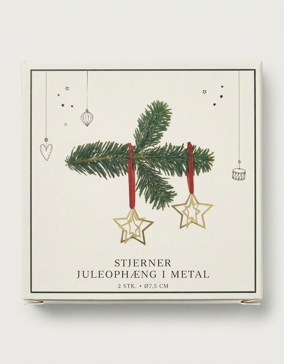 Set of two brass finish geometric star Christmas tree ornaments with red hanging ribbons in illustrated gift packaging.