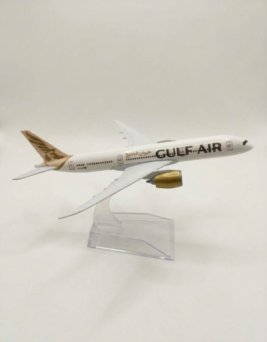 Side profile view of collectible Gulf Air metal airplane model with gold falcon tail art on acrylic desk stand.