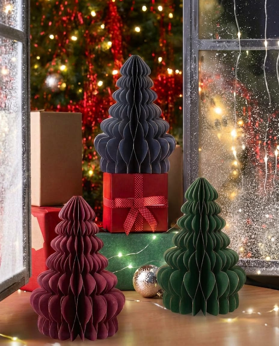 Set of 3 tabletop honeycomb paper Christmas trees in green, deep red, and navy blue with gold foil rims displayed on gift boxes for Christmas decor in Lebanon.