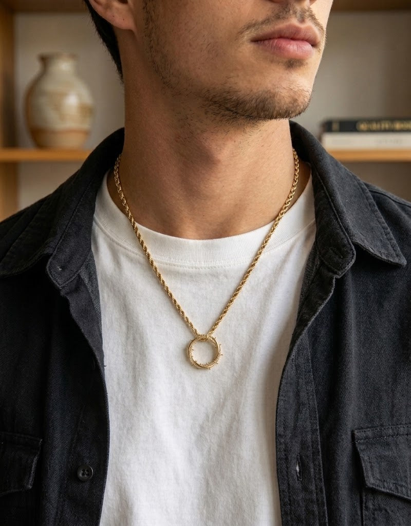 Male model wearing an 18K gold-plated crown of thorns pendant on a rope chain over a dark overshirt, Beirut Lebanon.