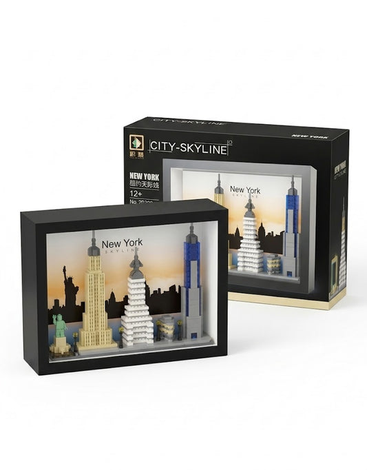 3D New York City skyline architecture building block set displayed inside a black shadow box frame next to retail packaging.