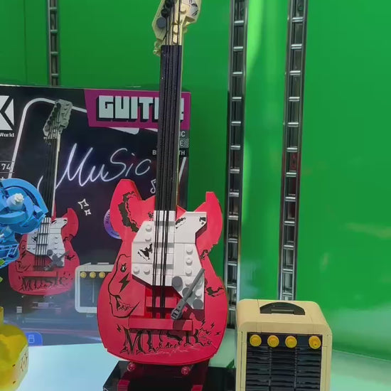Assembled red rock guitar brick model and mini amplifier speaker showcased on an illuminated store display video.