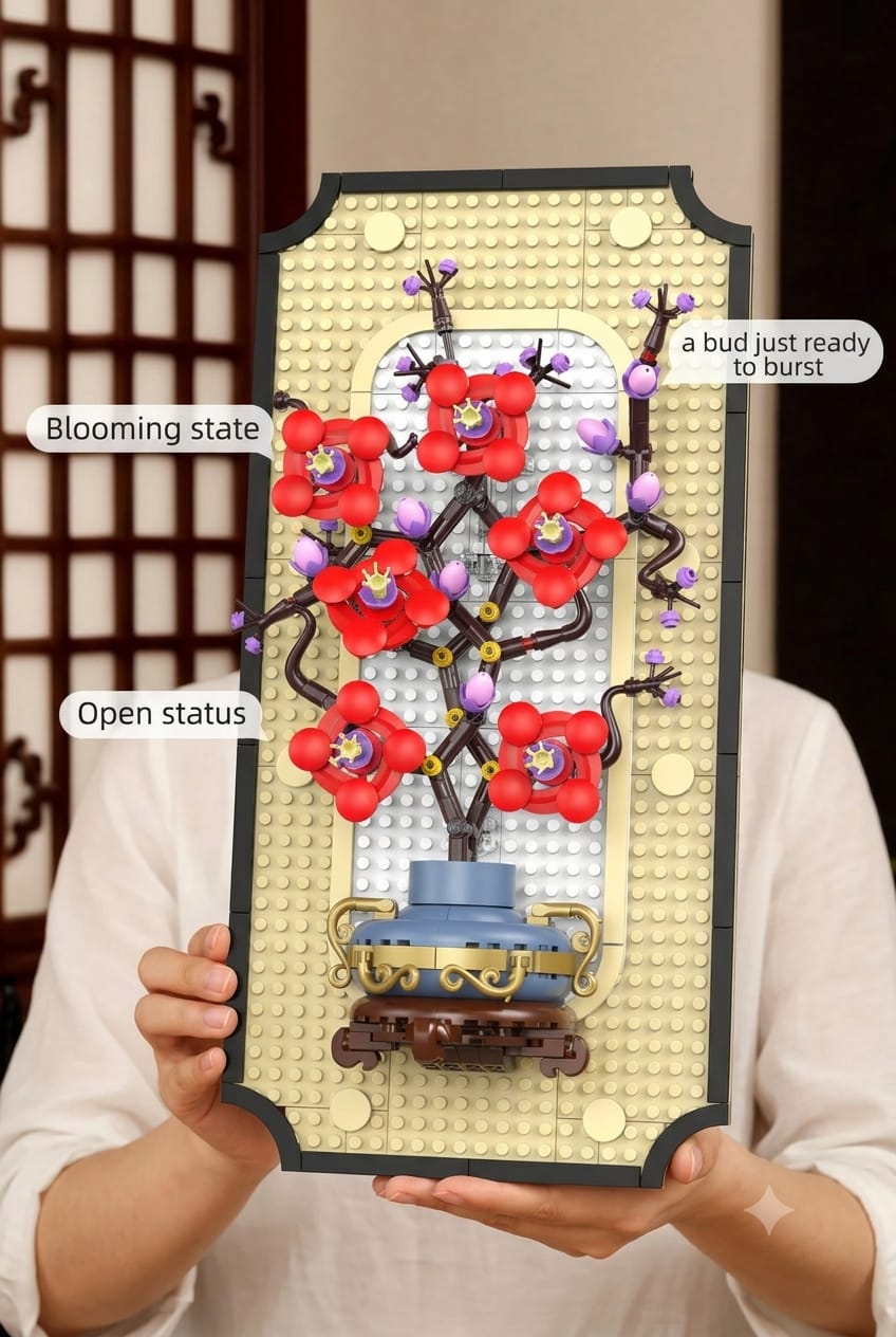 In-hand view of the assembled red plum blossom frame building set showing the scale, blooming petals, and bud details.