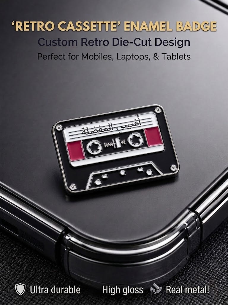 Black and silver metal retro cassette enamel badge with Arabic script adhered to a phone case
