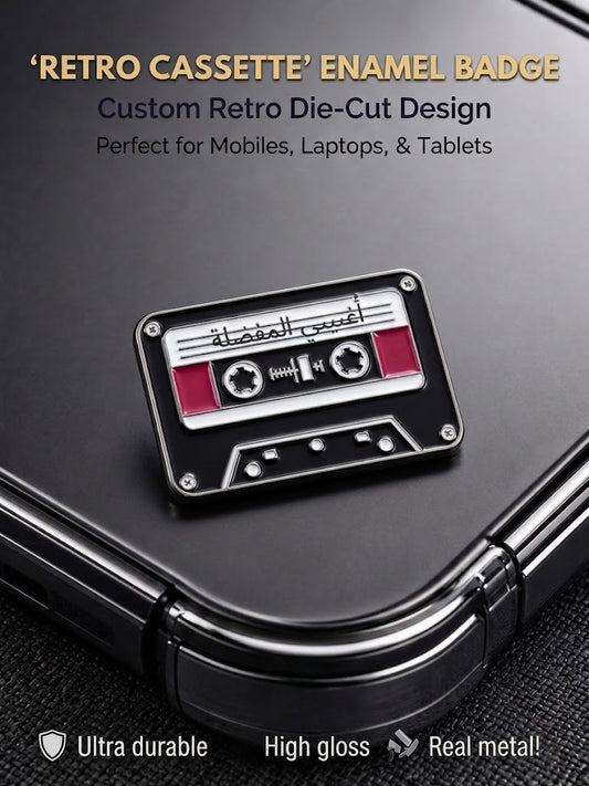 Black and silver metal retro cassette enamel badge with Arabic script adhered to a phone case