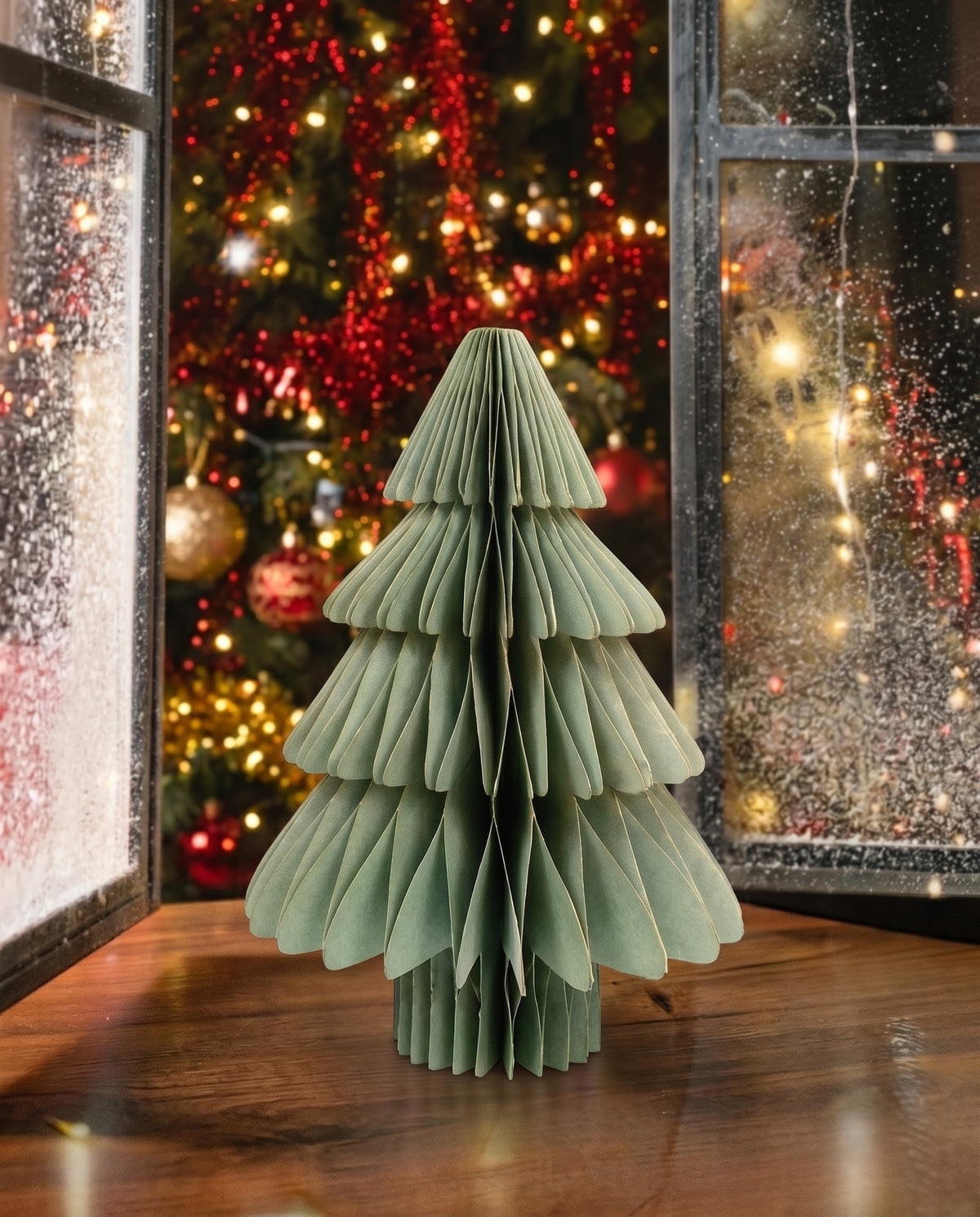 Sage green 3D accordion paper Christmas tree 34.5 cm with gold trim on a festive wooden windowsill, holiday home decor in Lebanon.
