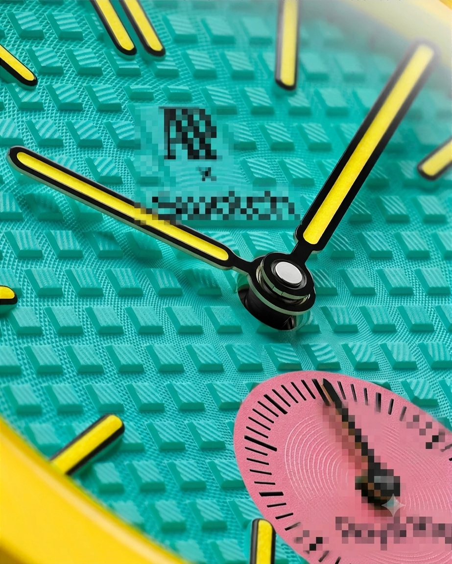 Macro close-up of textured turquoise tapisserie dial, yellow hands, and pink subdial on bioceramic pendant watch