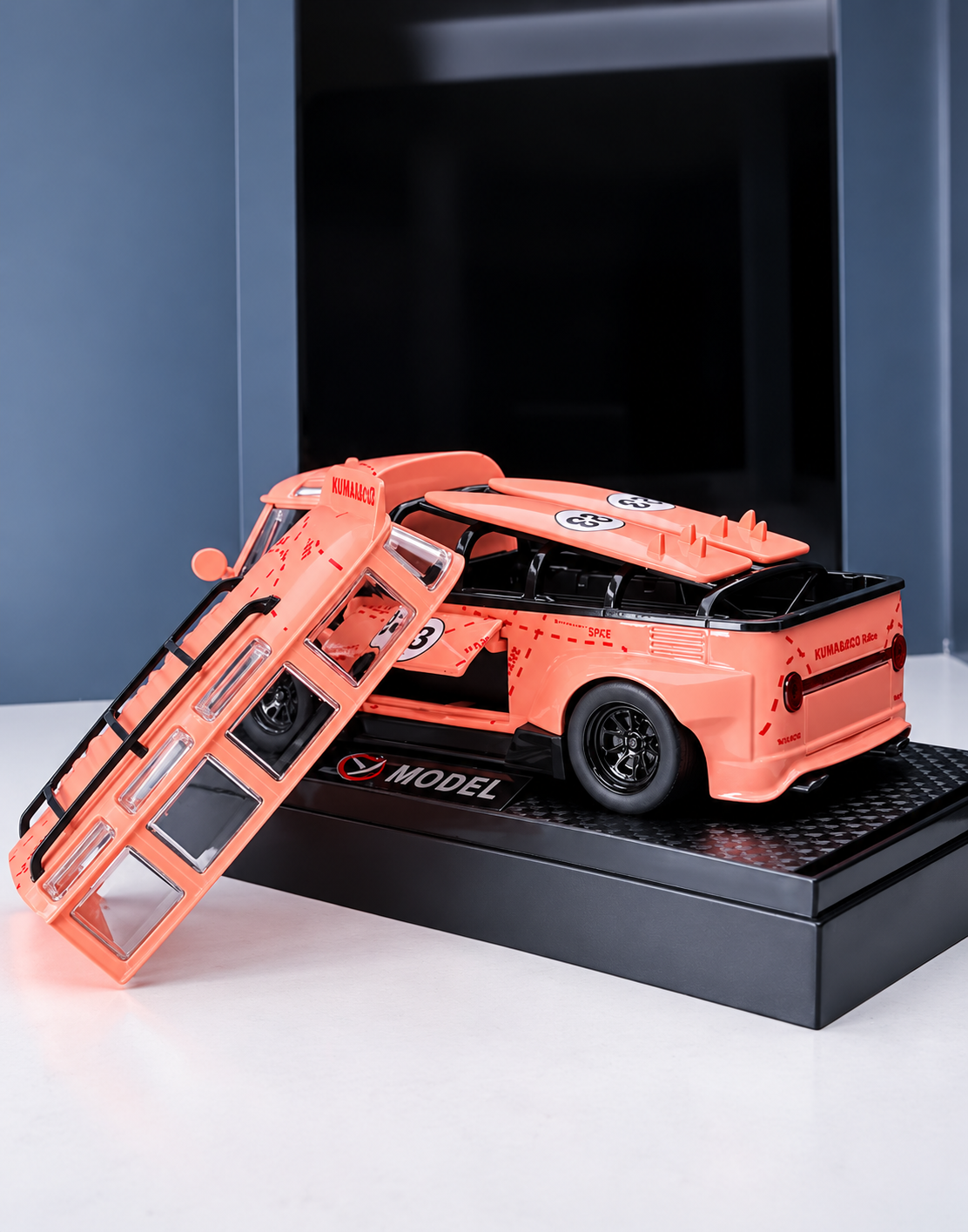 Rear view of custom pink racing van scale replica showing flared fenders, race livery accents, and detached roof frame beside display stand.